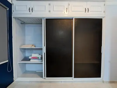 a closet with a black door and white cabinets at Apartamento a 5 min de la playa in San Felipe de Puerto Plata