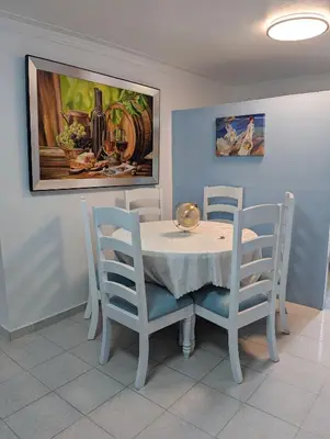 a dining room table and chairs with a painting on the wall at Apartamento a 5 min de la playa in San Felipe de Puerto Plata