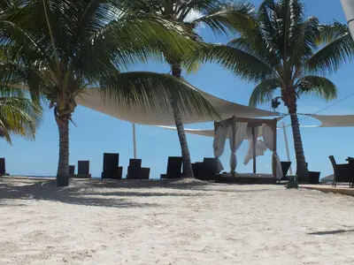 a tent and chairs on a beach with palm trees at Appartamenti in Cadaques Caribe in Bayahibe