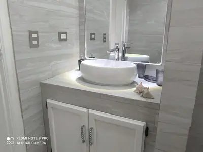 a bathroom with a sink and a cat laying on a counter at Villa Preciosa in Bayahibe