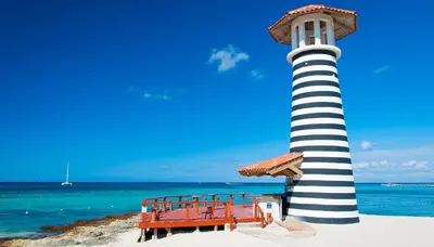 a lighthouse on the beach with a bench next to it at Casa Vacanze Dume in Bayahibe
