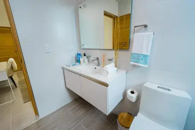 a white bathroom with a sink and a toilet at Stunning view of the city. in Santo Domingo
