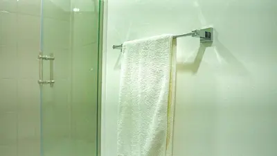 a shower with a white towel and a glass door at Premium space in Santiago- 5 Min Away from airport in Santiago de los Caballeros