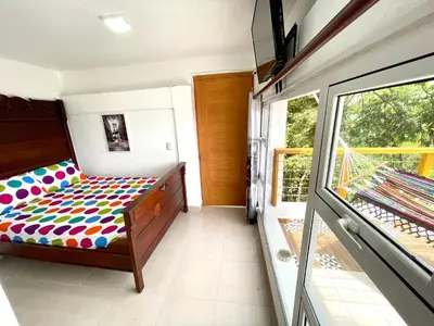a bedroom with a bed and a large window at Villa Leon in Jarabacoa