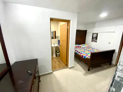 a small bedroom with a bed and a bathroom at Villa Leon in Jarabacoa