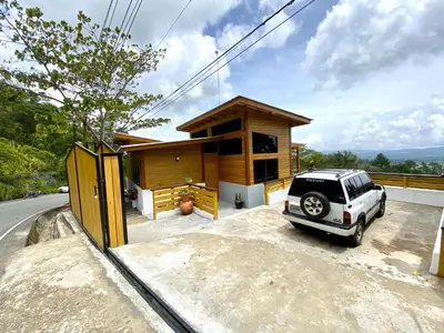 a car parked in front of a small house at Villa Leon in Jarabacoa