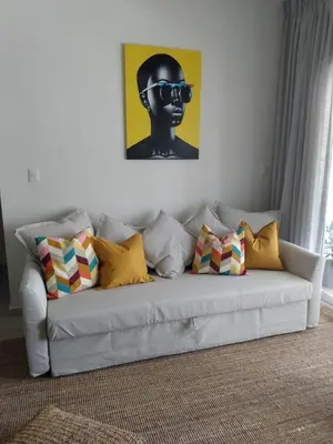 a white couch with pillows and a picture on the wall at Casa Mulata Paseo del Mar Pool & Playa in Punta Cana