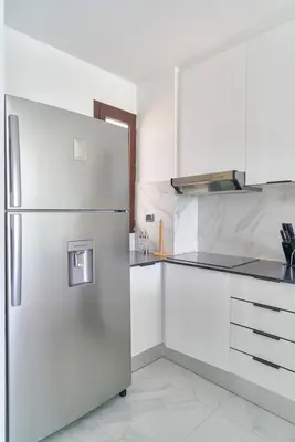 a kitchen with white cabinets and a refrigerator at Luxury Apartment at Cana Rock Star Punta Cana DR in Punta Cana