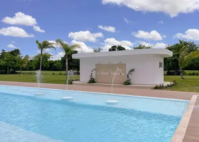 a swimming pool with a fountain in front of a building at Luxury Apartment at Cana Rock Star Punta Cana DR in Punta Cana