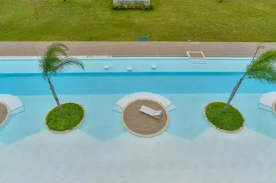 an overhead view of a pool with a table and palm trees at Luxury Apartment at Cana Rock Star Punta Cana DR in Punta Cana