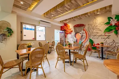 a restaurant with tables and chairs and a wall with flowers at Hotel Stay Here Suites in Santo Domingo