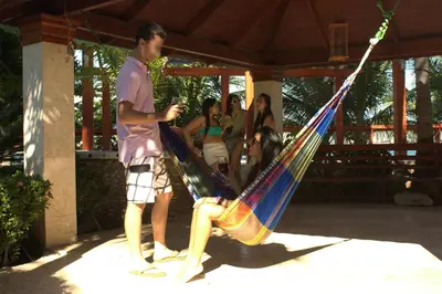 a man is holding a woman in a hammock at Sava Salinas in Las Salinas