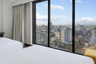 a bedroom with a large window with a view of a city at Aloft Santo Domingo Piantini in Santo Domingo