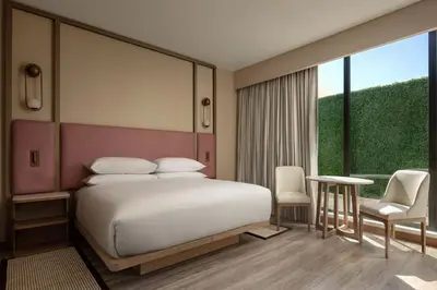 a bedroom with a white bed and a large window at Santo Domingo Marriott Hotel Piantini in Santo Domingo