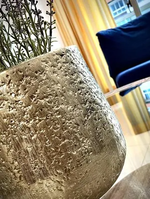 a silver vase with a plant in a room at VIP DELUXE SUITE AND TOWER E11 POOL_GYM_SAUNE_WIFE in Santo Domingo