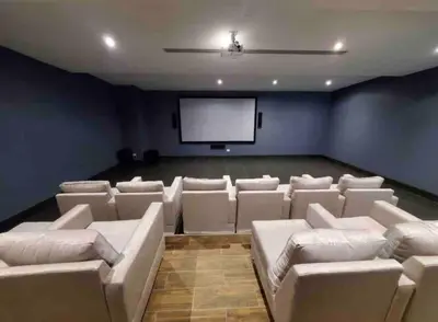 a cinema room with white couches and a screen at VIP DELUXE SUITE AND TOWER E11 POOL_GYM_SAUNE_WIFE in Santo Domingo