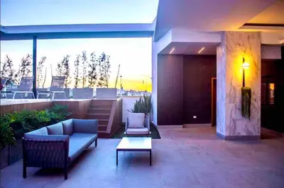 a patio with two chairs and a couch and a table at Luxury 1 BDR , Rooftop POOL, Gym, in Downtown D2 in Santo Domingo