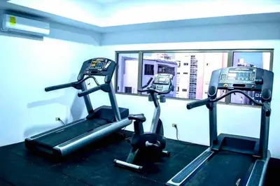a gym with two tread machines and a mirror at Luxury 1 BDR , Rooftop POOL, Gym, in Downtown D2 in Santo Domingo