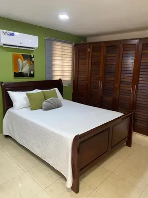 a bedroom with a large bed with wooden cabinets at Apartament para pareja muy acogedor y privado in Cafemba