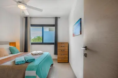 a bedroom with a bed with blue towels on it at The Garden | Beauty NEW 2 BR With Pool View in Punta Cana