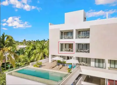 a white house with a swimming pool and palm trees at The Garden | Beauty NEW 2 BR With Pool View in Punta Cana