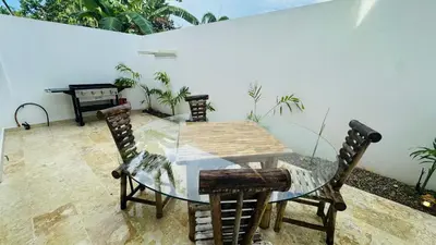 a table and chairs in a patio with plants at 3 Bedroom Beach Villa With Parking in Las Terrenas