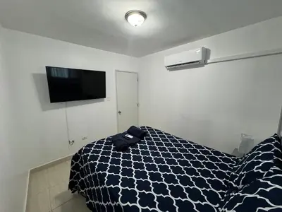 a bedroom with a bed and a flat screen tv at Joel Arturo Residences in Licey al Medio