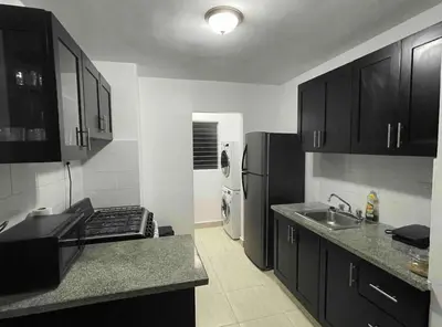 a kitchen with black cabinets and a stainless steel refrigerator at Joel Arturo Residences in Licey al Medio