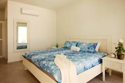 a bedroom with a bed with blue and white sheets at Villa Palmas Doradas in Cabarete