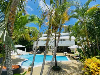 a resort with palm trees and a swimming pool at Casa Veintiuno in Sosúa