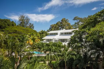 a white house with a swimming pool and trees at Casa Veintiuno in Sosúa