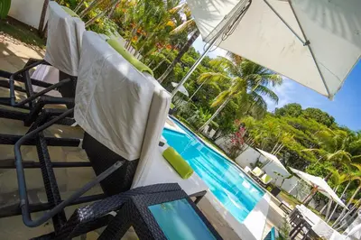 a chair and an umbrella next to a swimming pool at Casa Veintiuno in Sosúa