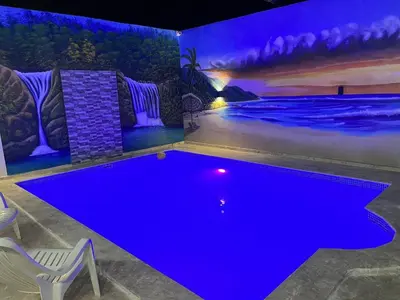 a swimming pool in a room with a blue lighting at R.G sol 2 in Pantoja