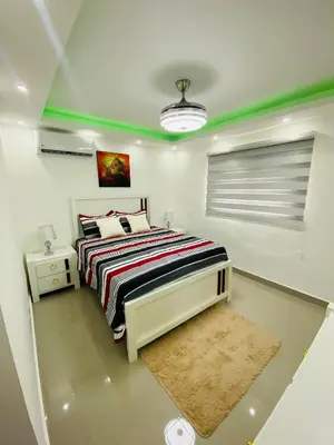 a bedroom with a bed with a striped comforter at Confortable y lujoso apartamento en santiago in Santiago de los Caballeros