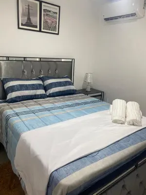 a large bed with blue and white sheets and pillows at Confortable y lujoso apartamento en santiago in Santiago de los Caballeros
