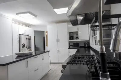 a kitchen with white cabinets and black counter tops at 8BR Penthouse Jacuzzi, Pool Table Terrace in Los Prados