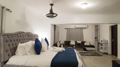 a bedroom with a large bed and a living room at 8BR Penthouse Jacuzzi, Pool Table Terrace in Los Prados