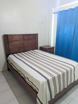 a bed in a room with a blue curtain at Espacioso apartamento en Puerto Plata in San Felipe de Puerto Plata