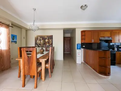 a kitchen with a wooden table and wooden cabinets at Espacioso apartamento en Puerto Plata in San Felipe de Puerto Plata