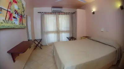 a bedroom with a bed and a desk and a window at Villa La Plantacion in Las Galeras
