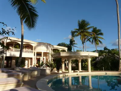 a house with a swimming pool and palm trees at Villa La Plantacion in Las Galeras