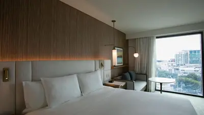 a hotel room with a bed and a large window at Courtyard by Marriott Santo Domingo Piantini in Santo Domingo