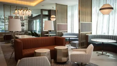 a lobby with a couch and chairs and tables at Courtyard by Marriott Santo Domingo Piantini in Santo Domingo