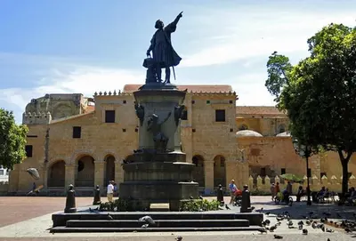 a statue in front of a building with birds around it at Hostal María Fernanda in Santo Domingo