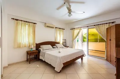 a bedroom with a bed and a sliding glass door at Alicia Beach, Hispaniola Sol! in Sosúa