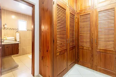 a bathroom with a wooden shower stall and a sink at Alicia Beach, Hispaniola Sol! in Sosúa