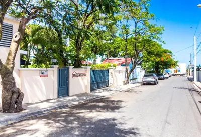 a car parked on the side of a street with trees at Alicia Beach, Hispaniola Sol! in Sosúa