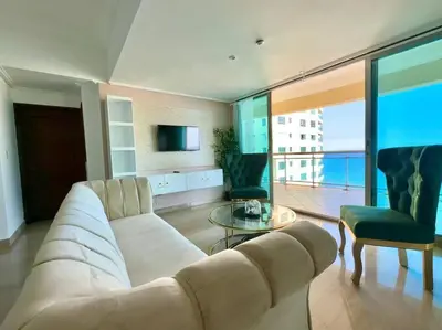 a living room with a couch and a table and a tv at 3 BDR Ocean View luxury Apartment . Sleeps 6 in Santo Domingo