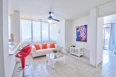 a living room with a couch and a red chair at Rentamos Aparta Estudio for short or long stay in Santo Domingo