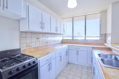 a kitchen with white cabinets and a stove top oven at Rentamos Aparta Estudio for short or long stay in Santo Domingo
